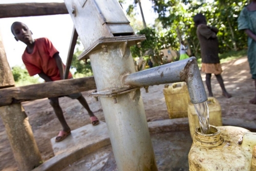 Boys fill containers with water at a borehole donated by the Rotary Club of Muyenga, Uganda.