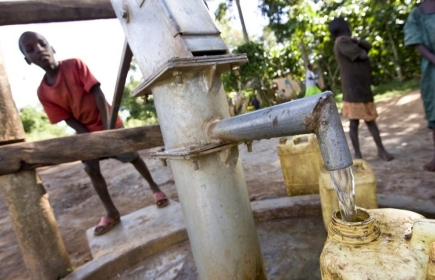 Boys fill containers with water at a borehole donated by the Rotary Club of Muyenga, Uganda.